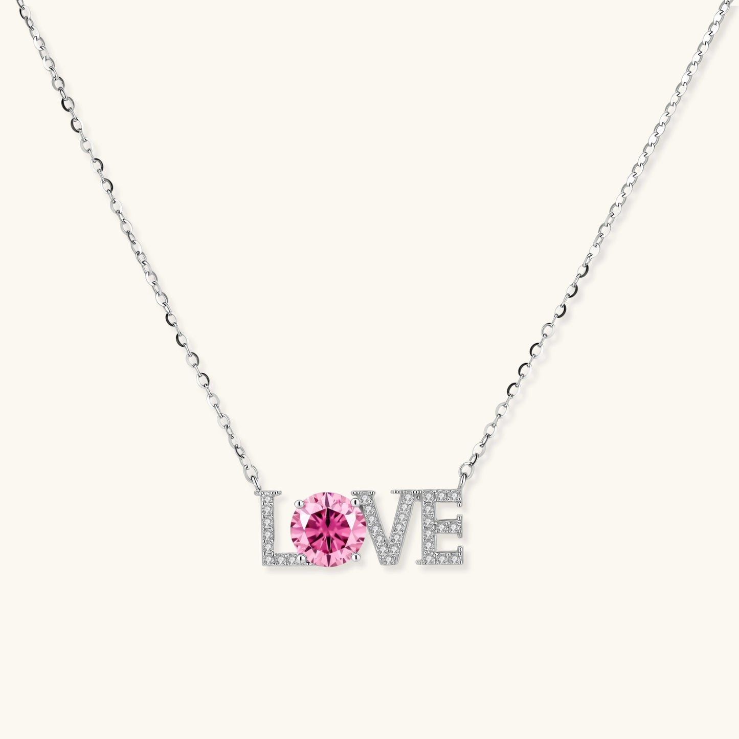 Sterling silver LOVE necklace with pink moissanite stone replacing the O, featuring crystal-set letters on delicate chain.