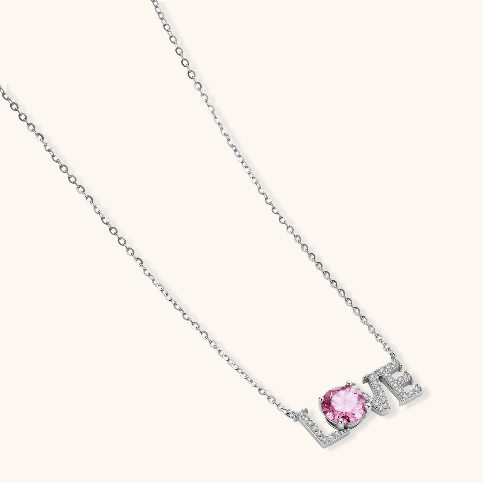 Sterling silver LOVE necklace with pink moissanite stone replacing the O, featuring crystal-set letters on delicate chain.