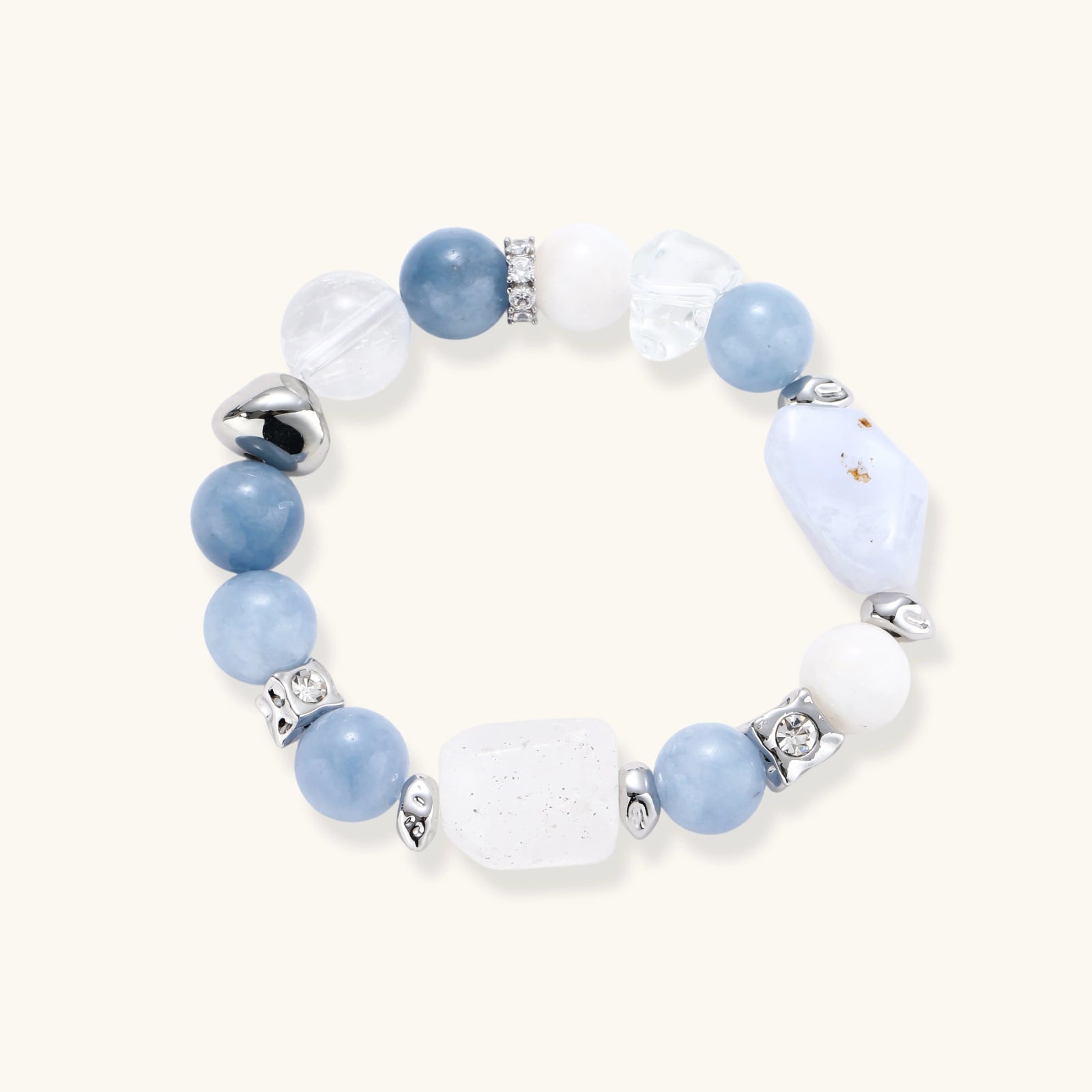 Stretchable bracelet with blue aquamarine beads, clear quartz crystals and copper accents on white background.