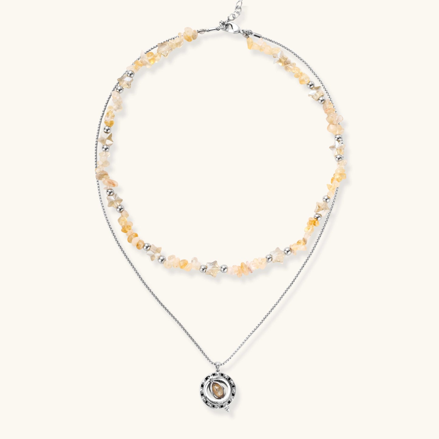 Two-layer necklace with natural stone chips and eco-brass beads, featuring a circular wrapped pendant on cream background.