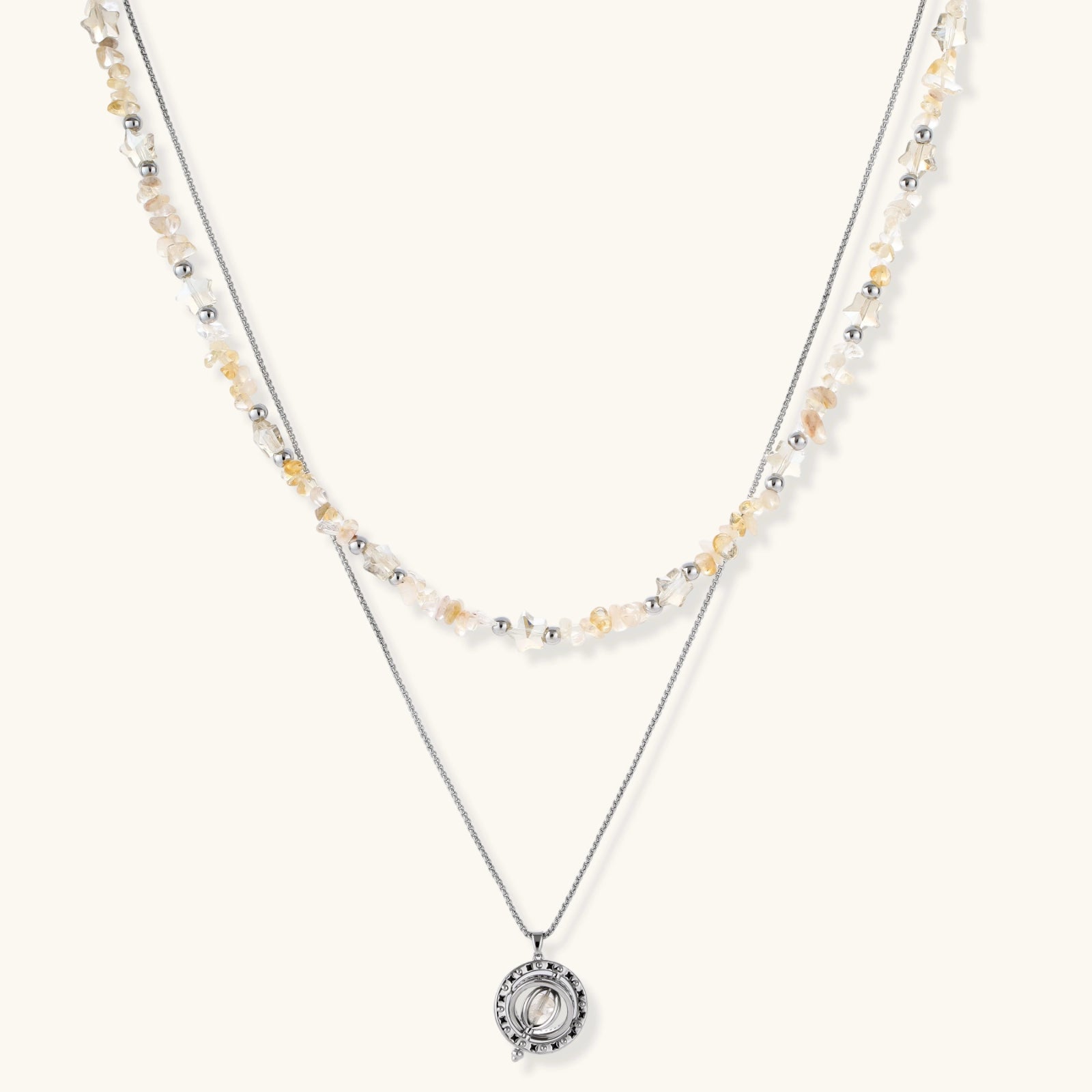 Two-layer necklace with natural stone chips and eco-brass beads, featuring a circular wrapped pendant on cream background.