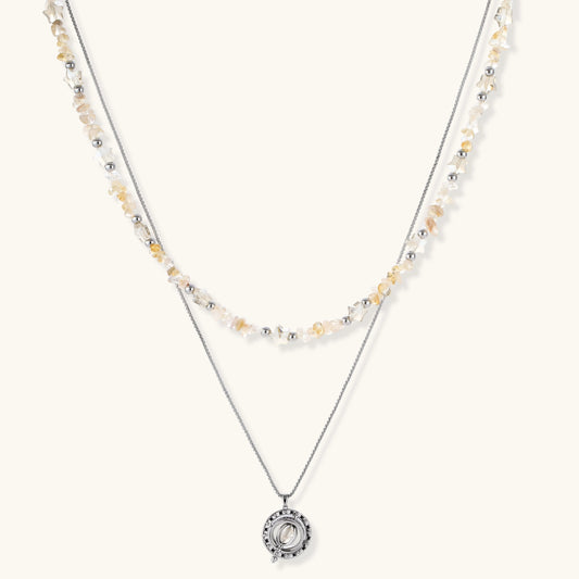 Two-layer necklace with natural stone chips and eco-brass beads, featuring a circular wrapped pendant on cream background.