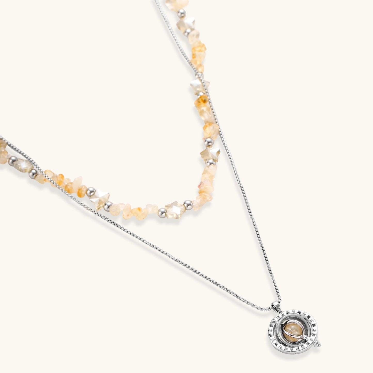 Two-layer necklace with natural stone chips and eco-brass beads, featuring a circular wrapped pendant on cream background.