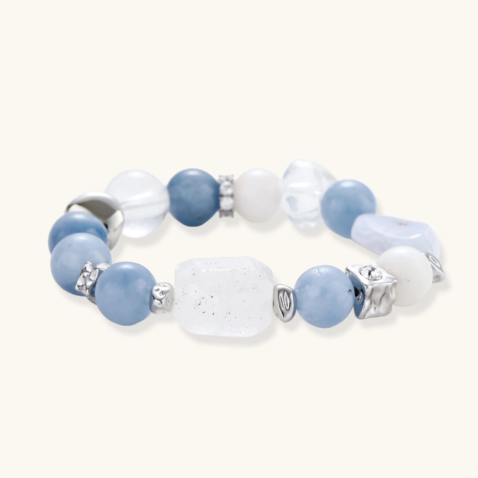 Stretchable bracelet with blue aquamarine beads, clear quartz crystals and copper accents on white background.
