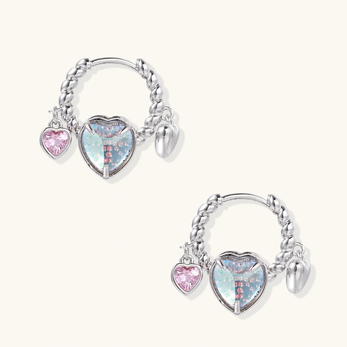 Silver chain hoop earrings with iridescent opal heart charms and pink zirconia accents on white background