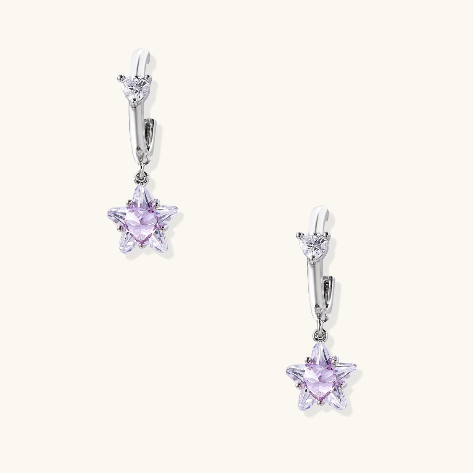 White gold plated huggie earrings with clear CZ accents and dangling lavender star-shaped crystals on cream background