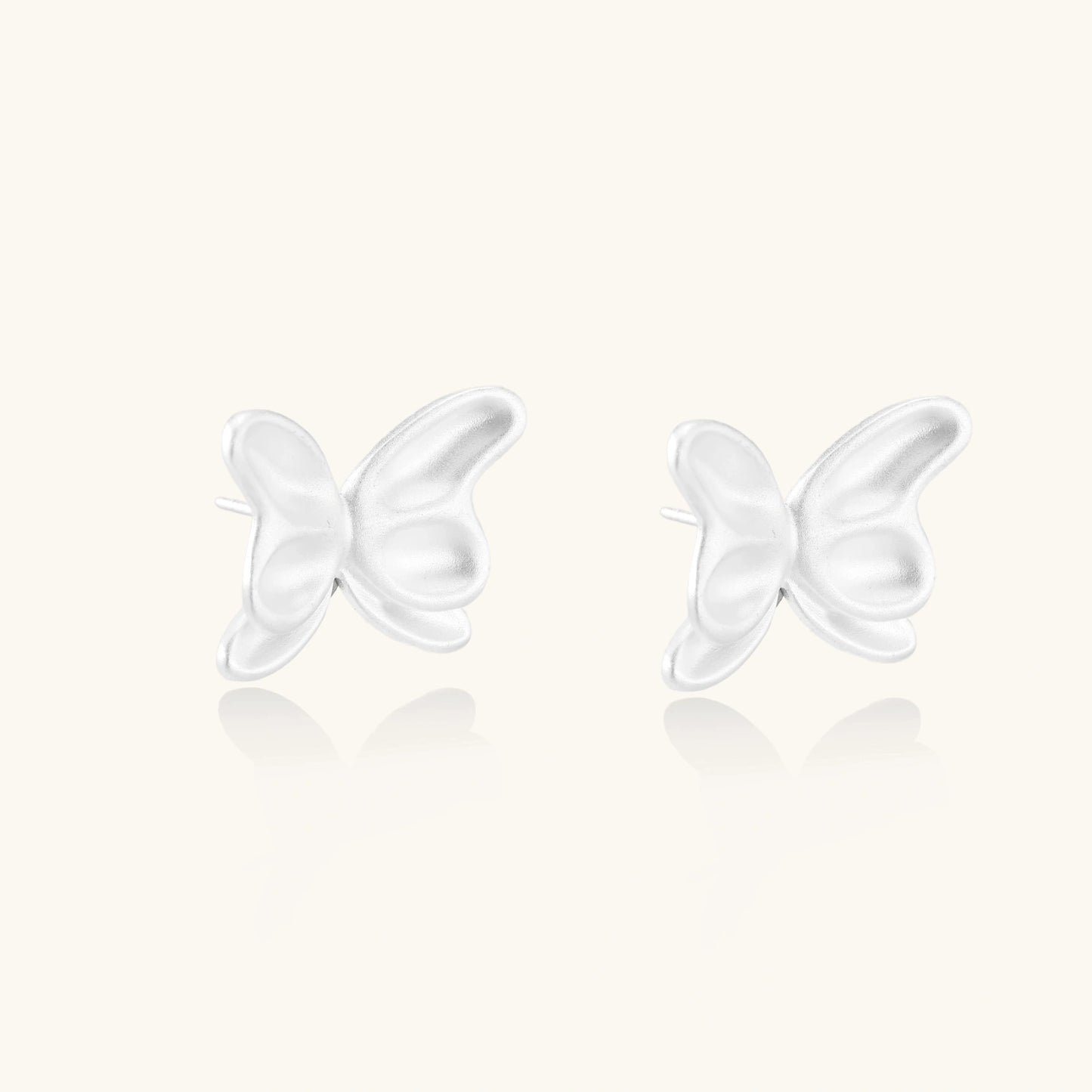 Pair of translucent butterfly-shaped stud earrings with frosted finish and dimensional wing details on white background