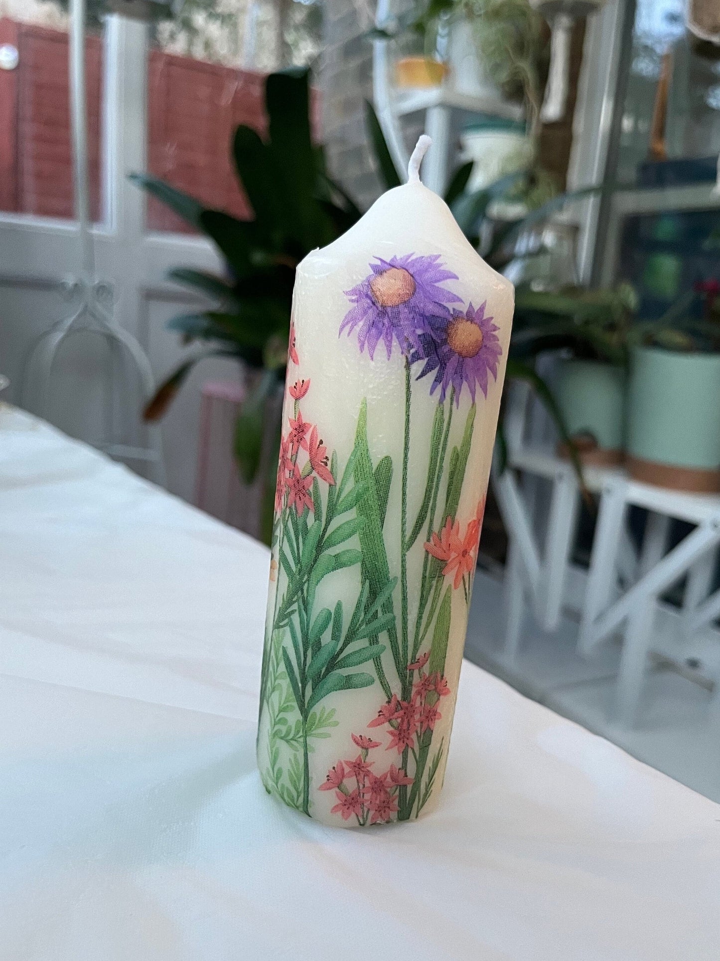 Pillar candle with floral, multiple flowers growing up from the bottom of the candle to the top , 50 hour burning