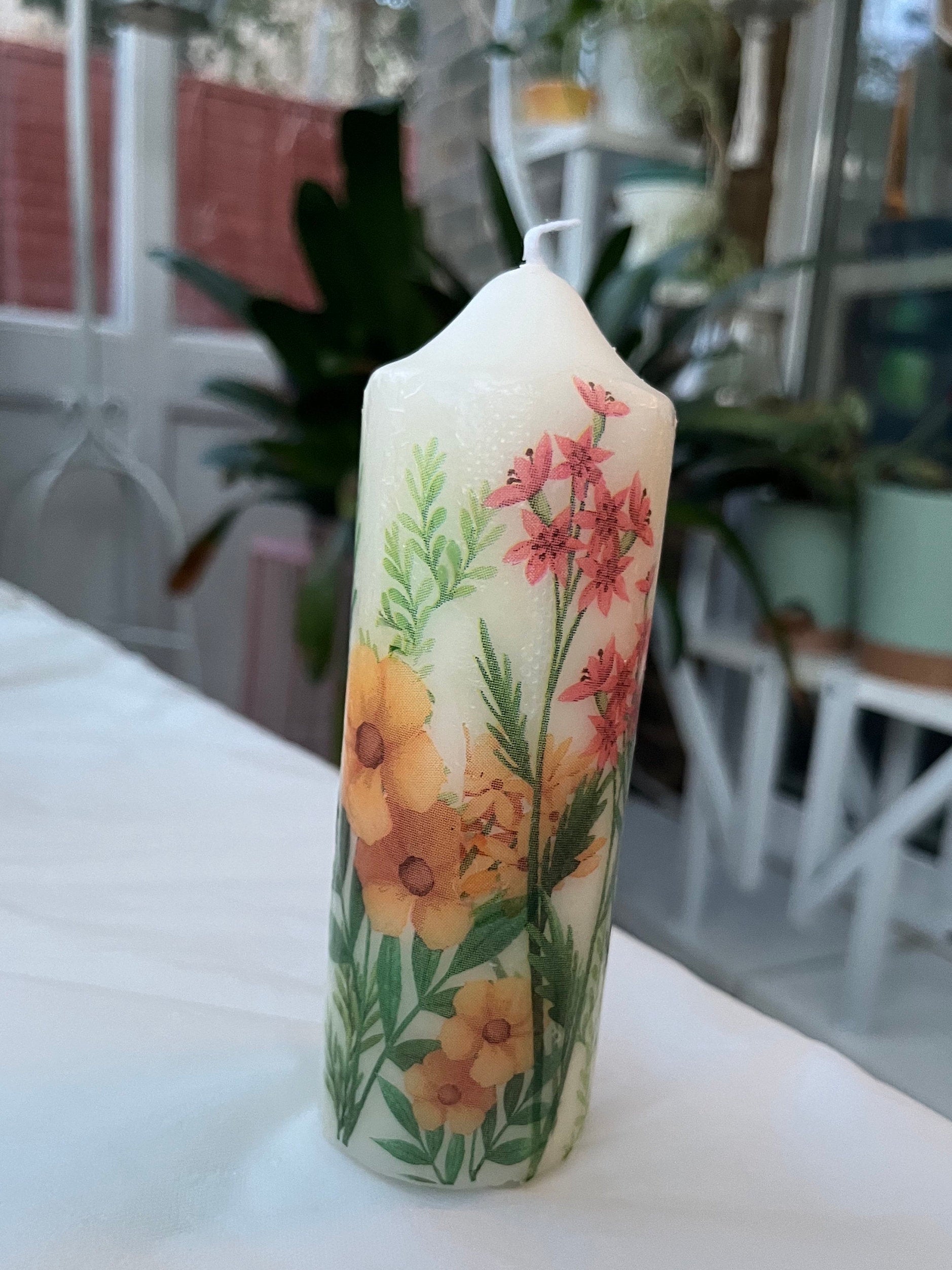 Pillar candle with floral, multiple flowers growing up from the bottom of the candle to the top , 50 hour burning