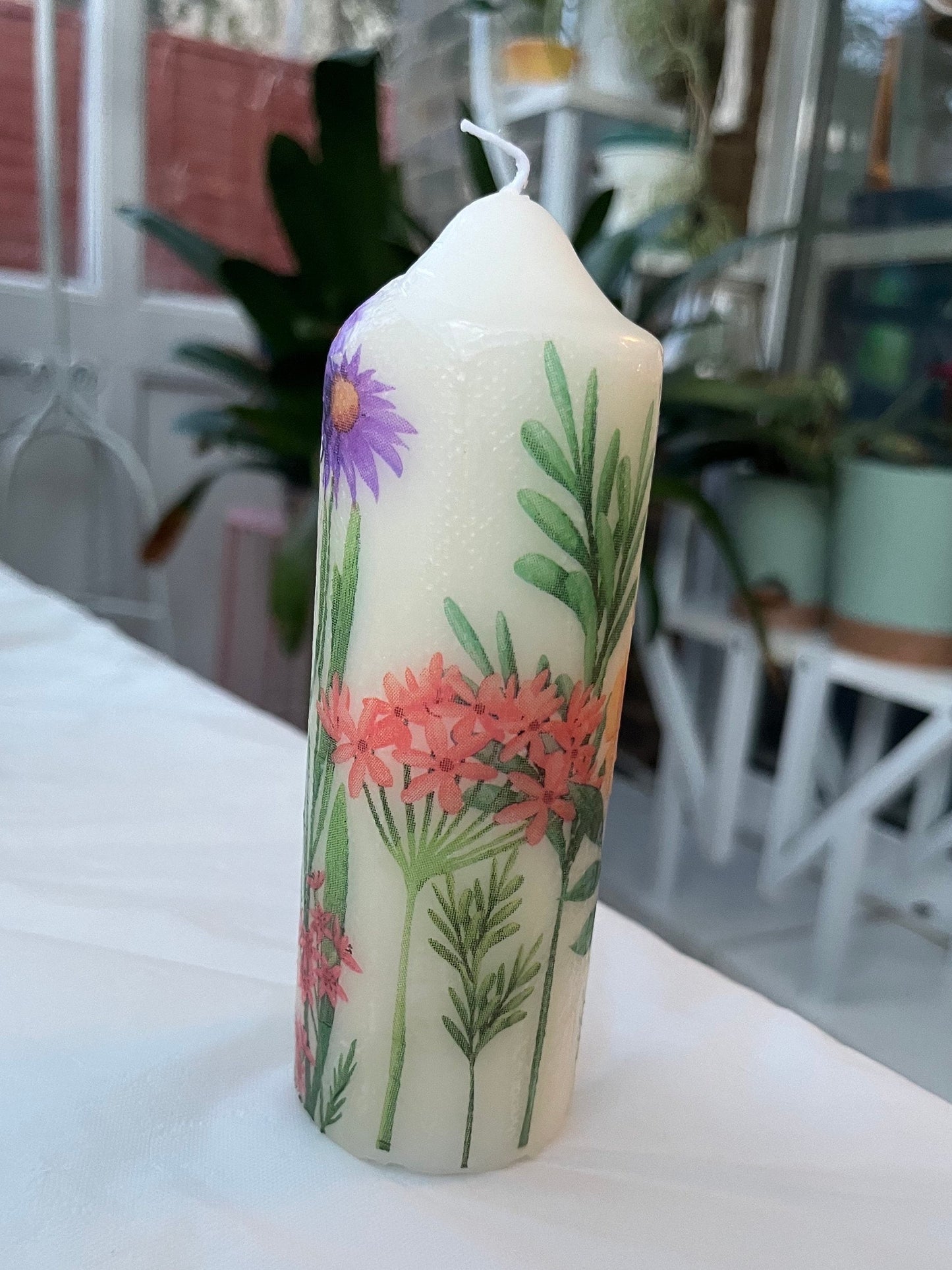 Pillar candle with floral, multiple flowers growing up from the bottom of the candle to the top , 50 hour burning