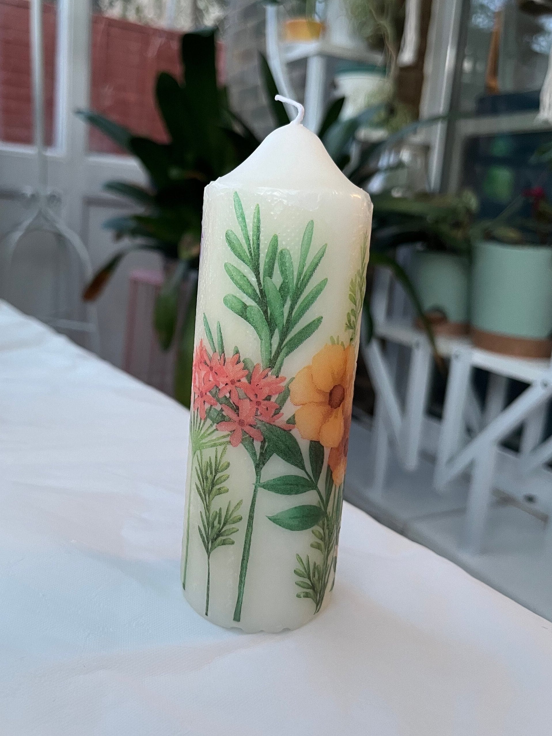 Pillar candle with floral, multiple flowers growing up from the bottom of the candle to the top , 50 hour burning